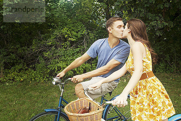 Pärchen küsst sich beim Fahrradfahren im Park