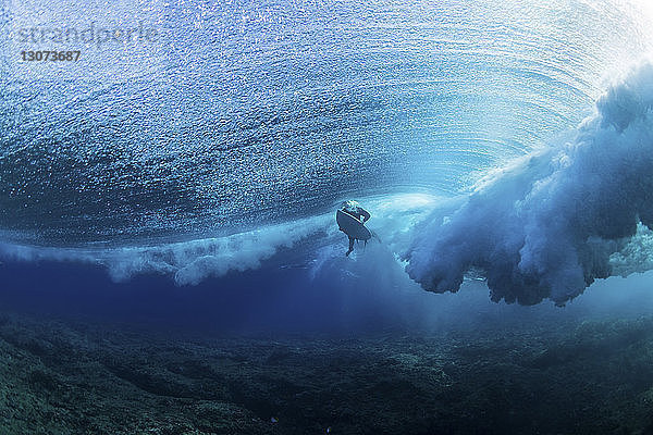 Niedrigwinkelansicht eines Mannes  der im Meer unter Wasser surft