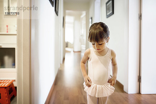 Süßes Mädchen im Ballerina-Kostüm zu Hause stehend