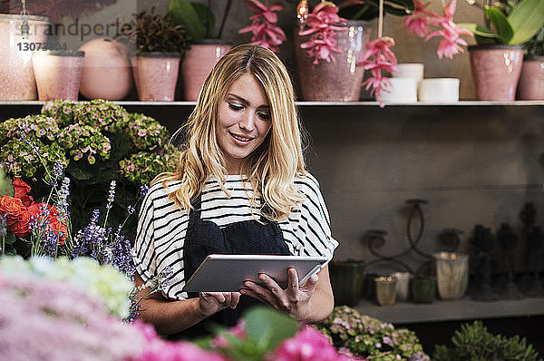 Florist mit Tablet-Computer im Blumengeschäft