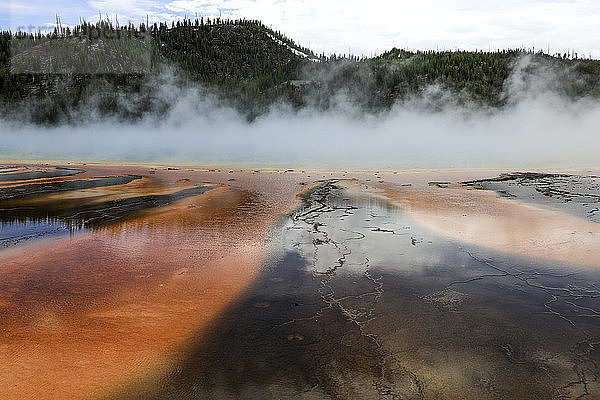 Idyllischer Blick auf eine rauchende heiße Quelle vor den Bergen im Yellowstone-Nationalpark