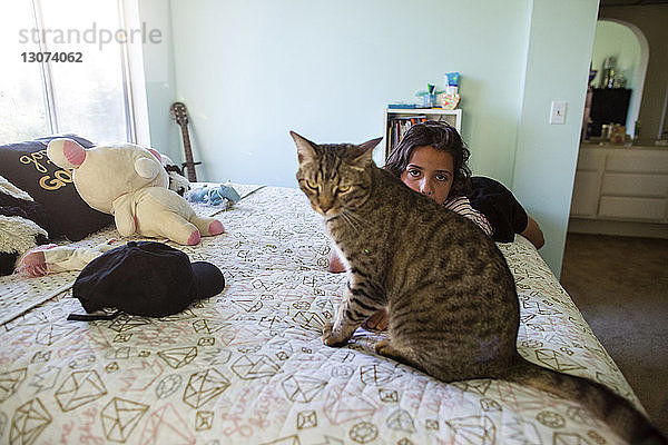 Porträt eines Mädchens mit Katze im Schlafzimmer