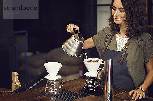 Weiblicher Barista bereitet Kaffee im Café zu