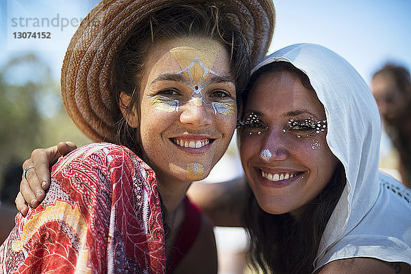 Porträt von lächelnden Freunden mit Gesichtsbemalung bei traditioneller Veranstaltung