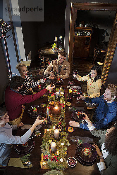 Freunde stoßen zu Weihnachten beim Essen auf Wein an