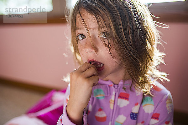 Porträt eines Mädchens  das zu Hause einen Zahn berührt