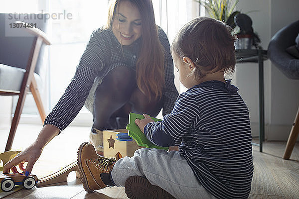 Mutter und Sohn spielen zu Hause mit Spielzeug