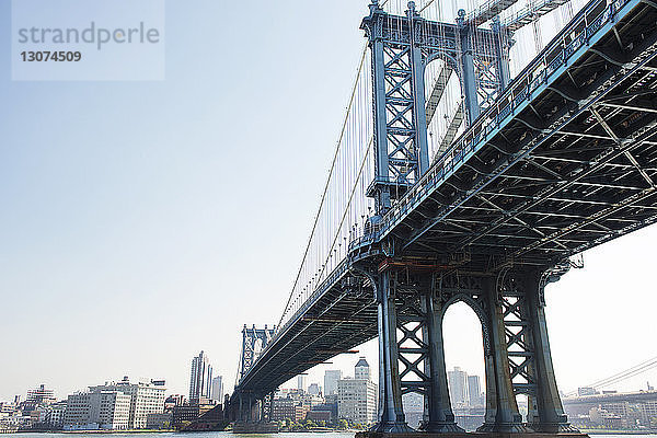 Tiefblick auf die Manhattan Bridge über den East River bei klarem Himmel