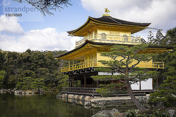 Blick auf den Kinkaku-ji-Tempel am Teich vor bewölktem Himmel
