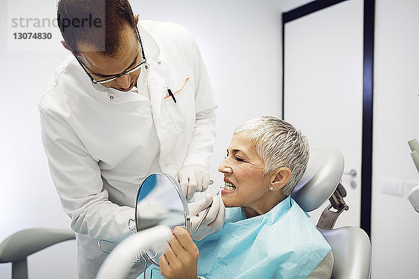 Zahnarzt kontrolliert die Zähne der Frau in der Klinik