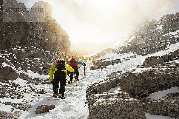 Niedrigwinkelansicht von Männern  die auf dem schneebedeckten Mount Whitney wandern