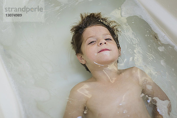 Hochwinkelporträt eines Jungen in der Badewanne