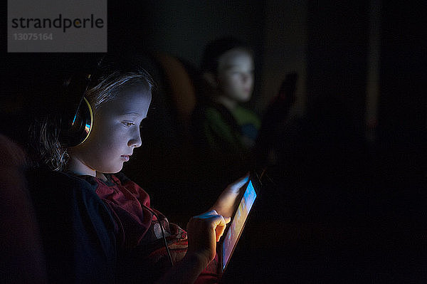 Junge benutzt Tablet-Computer in der Dunkelkammer zu Hause