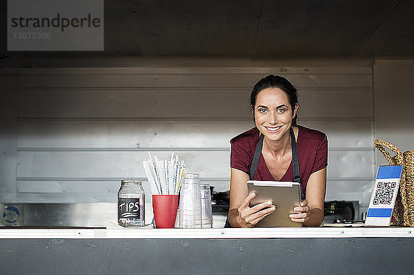 Porträt einer Verkäuferin mit Tablet-Computer im Speisewagen