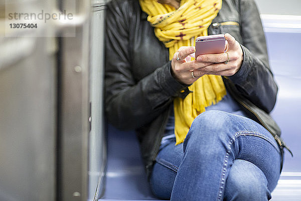 Ein Teil der Frau benutzt ein Smartphone während einer Zugfahrt