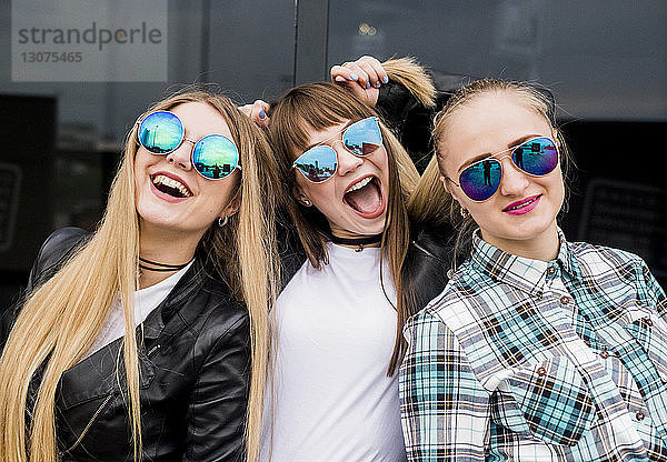 Porträt von glücklichen Freundinnen mit Sonnenbrille in der Stadt