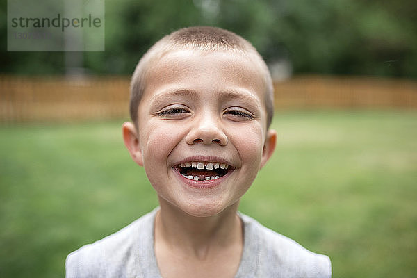Nahaufnahme-Porträt eines glücklichen Jungen  der im Park steht