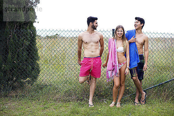 Glückliche Freunde in Badebekleidung stehen auf dem Hof