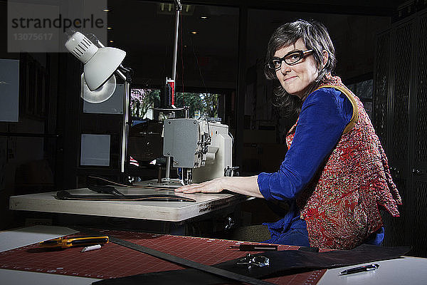 Porträt einer Frau mit Nähmaschine in der Werkstatt