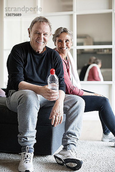 Porträt eines sportlichen Paares  das zu Hause auf dem Sofa sitzt