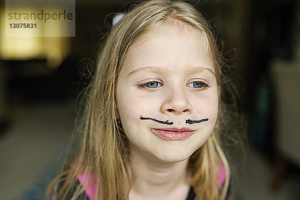 Mädchen mit Schnurrbart-Gesichtsbemalung zu Hause