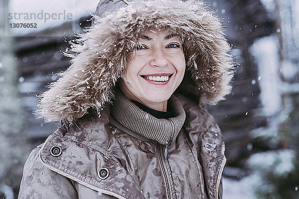 Nahaufnahme einer glücklichen Frau  die bei Schneefall im Freien steht