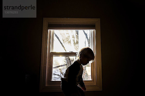 Scherenschnitt Junge am Fenster in der Dunkelkammer zu Hause