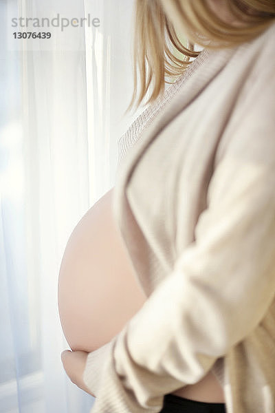 Seitenansicht Mittelteil einer schwangeren Frau zu Hause
