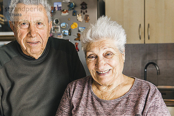 Porträt eines älteren Ehepaares  das zu Hause in der Küche steht