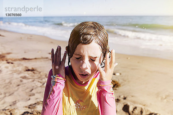 Nahaufnahme eines nassen Mädchens  das an einem sonnigen Tag am Strand steht