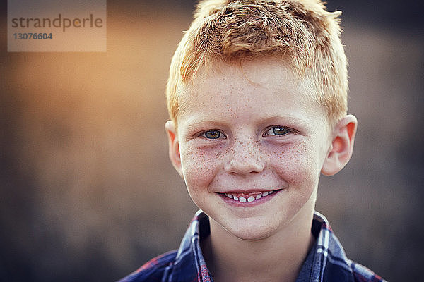 Porträt eines lächelnden Jungen an einem sonnigen Tag