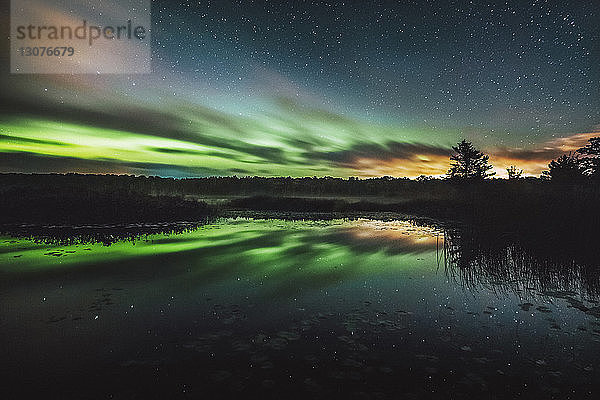 Reflexion des Nordlichts auf einem ruhigen See bei Nacht