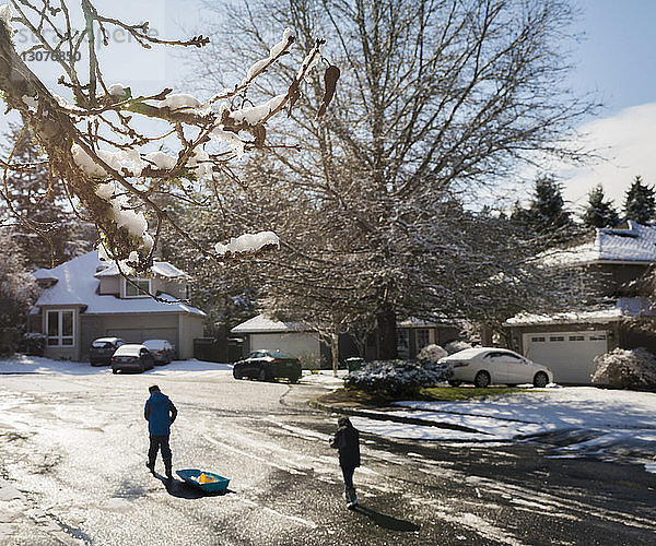 Hochwinkelaufnahme von Brüdern  die im Winter auf der Straße gehen