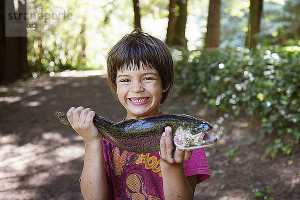 Junge hält Fisch