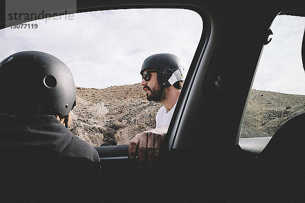 Sohn mit Helm im Auto  Vater gegen Berg