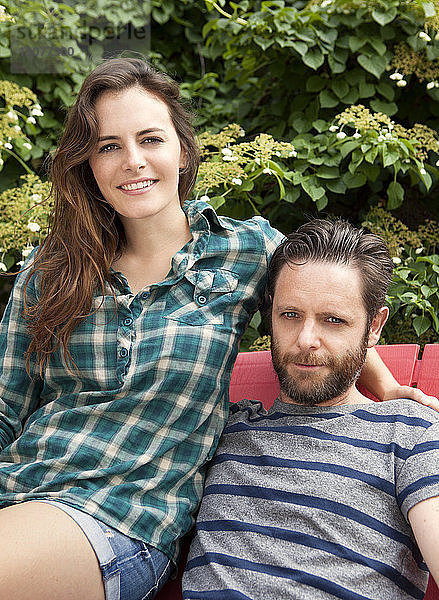 Porträt eines auf einem Stuhl sitzenden Paares auf einem Rasen
