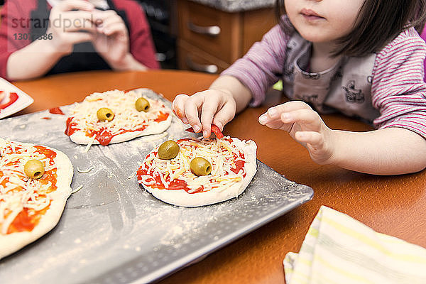 Kinder bereiten Mini-Pizzas zu