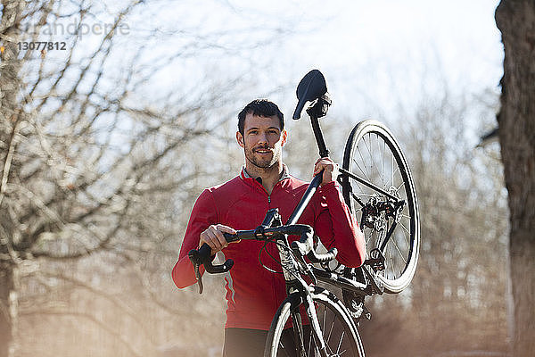 Porträt eines Athleten mit Fahrrad im Wald