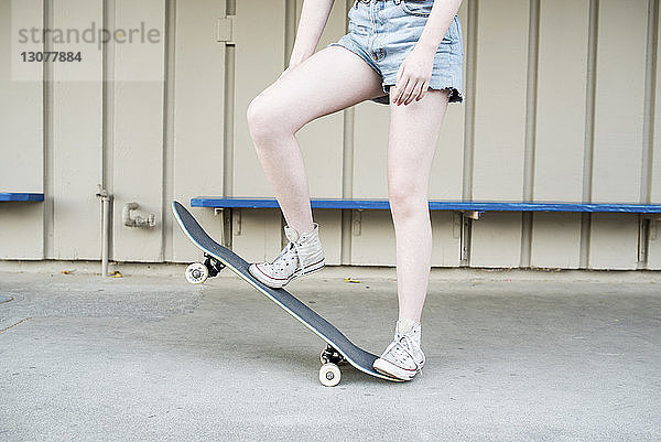 Niedriger Abschnitt eines Teenager-Mädchens beim Skateboarden im Park