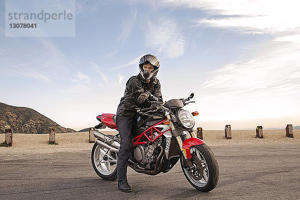 Porträt eines auf einem Motorrad sitzenden Bikers mit Helm