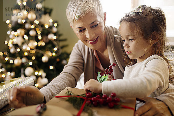 Großmutter betrachtet Mädchen als Dekorationsgeschenk