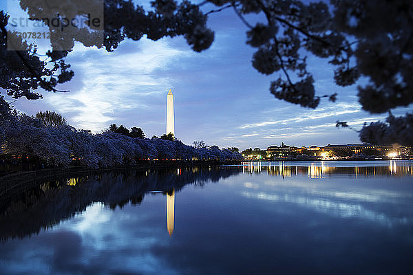 Washington Monument am See gegen bewölkten Himmel in der Abenddämmerung