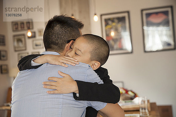 Sohn umarmt Vater zu Hause