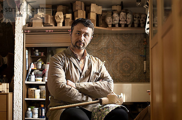 Porträt eines selbstbewussten Handwerkers  der in der Werkstatt sitzt