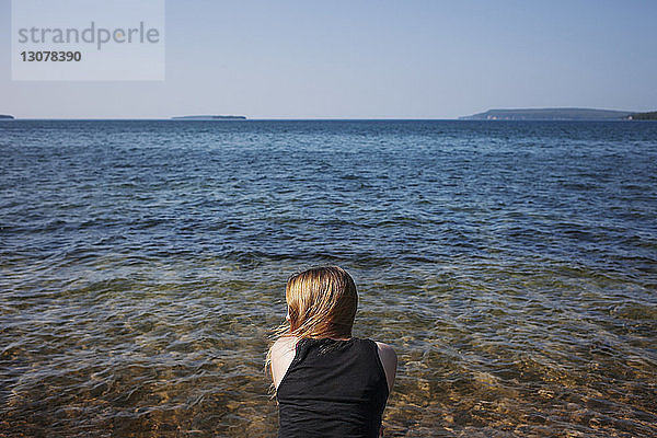 Rückansicht einer Frau gegen das Meer an einem sonnigen Tag