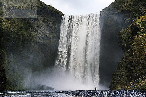 Fernansicht eines Mannes  der am Wasserfall steht