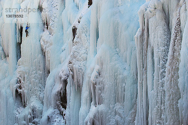 Person besteigt eisbedeckten Berg