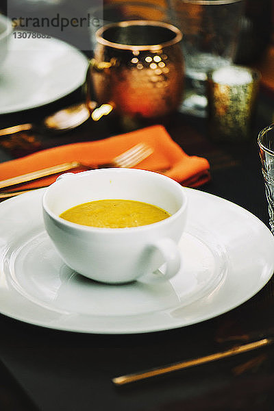 Nahaufnahme einer Kürbissuppe  die in einer Schüssel auf dem Tisch serviert wird