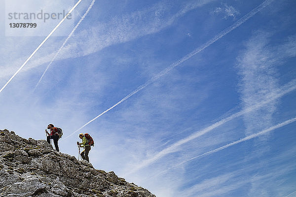 Niedrigwinkelansicht von Wanderern  die Berg gegen Himmel klettern