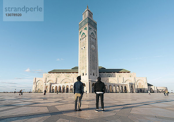Rückansicht von Freunden  die sich gegen die Moschee Hassan II stellen